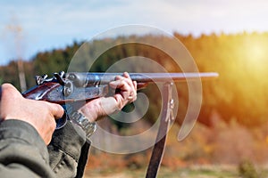 Hunter with retro shotgun aims at the target. Hunting season