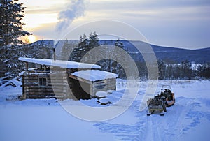 Hunter`s hut and  snowmobile in winter in the floodplain of the Lena River