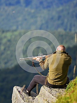 Hunter spend leisure hunting. Man brutal gamekeeper nature landscape background. Hunting in mountains. Hunting masculine photo