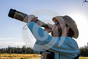 Hunter using a elk bugle mew call in snowy range mountains in Wyoming