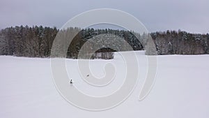 A hunter in white camouflage during the winter hunting season.