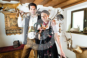 Hunter and woman in an alpine mountain hut with horn