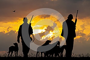 Hunters with dogs at sunset