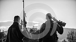 Hunters friends enjoy leisure. Hunters friends gamekeepers with guns silhouette sky background. Hunters rifles nature