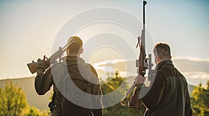 Hunters friends enjoy leisure. Hunters friends gamekeepers with guns silhouette sky background. Hunters rifles nature