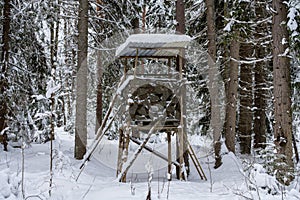 Hunters nest or tower in the middle of the forest in winter