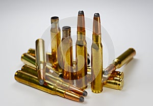 Hunting ammunition and empty rifle bullet cartridges on whitye.