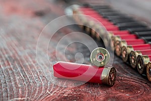 Hunting cartridges in patronage are lying on a wooden table close-up. The hunting period, the season is open