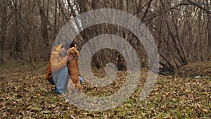 Hunting dog licks and rejoices its owner in autumn park. Slow motion.