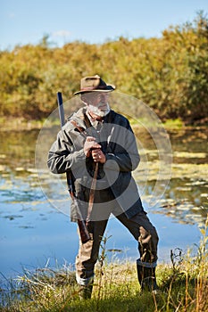 Handsome hunter near lake