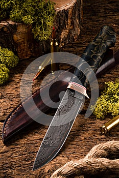 Hunting equipment. Shotgun, hunting cartridges and hunting knife on wooden table