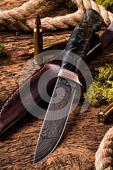 Hunting equipment. Shotgun, hunting cartridges and hunting knife on wooden table