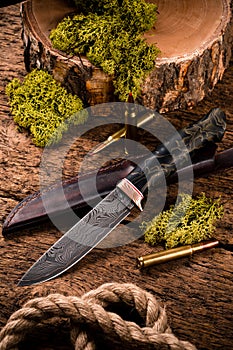 Hunting equipment. Shotgun, hunting cartridges and hunting knife on wooden table