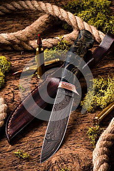 Hunting equipment. Shotgun, hunting cartridges and hunting knife on wooden table