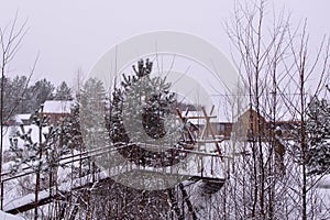 Hunting estate in the winter forest. winter landscape with bridge, trees and wooden house