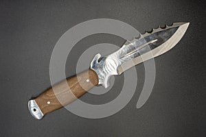 Hunting knife with teeth  on gray background. knife barbs