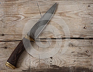 Hunting knife on a wooden background