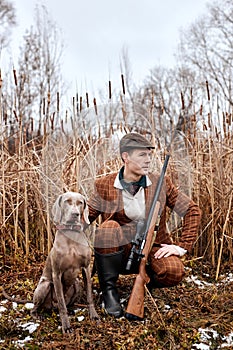 Hunting period, autumn season open. confident caucasian hunter with dog and gun