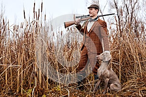 Hunting period, autumn season open. confident caucasian hunter with dog and gun