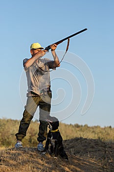 Hunting period, autumn season open. A hunter with a gun in his hands in hunting clothes