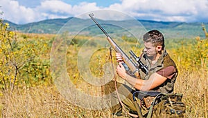 Hunting shooting trophy. Hunter with rifle looking for animal. Hunting hobby and leisure. Man charging hunting rifle