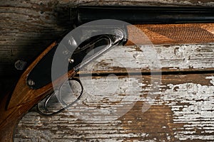 Hunting shotgun riffle on old rustic wooden table