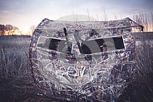 Hunting tent with hunters waiting for prey in reed bushes