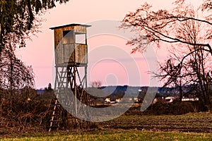 Hunting tower after sunset in rural scenery against pink sky. Deer stand near Zettling Graz in Austria.