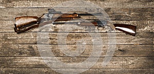 Hunting weapon on dark wooden backgorund, top view