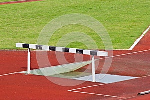 Hurdles on the red running track prepared for competition.