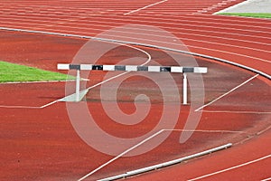 Hurdles on the red running track prepared for competition.