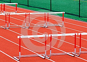 Hurdles set up on a red track for an outdoor race