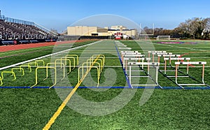 Hurdles set up for stength and agility practice on a turf athletic field