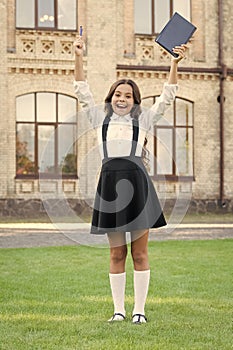 Hurray for school holidays. Happy child finish primary school. Cute little girl celebrate in formal school uniform. End