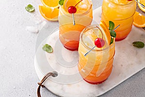 Hurricane cocktail in tiki glasses, tropical, rum-based cocktail with orange and cherry for garnish