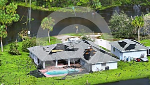 Hurricane Ian destroyed house with damaged roof and lanai enclosure in Florida residential area. Natural disaster and