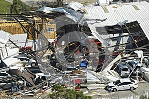 Hurricane Ian destroyed industrial building with damaged cars under ruins in Florida. Natural disaster and its