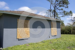 Hurricane shutters made from plywood mounted for protection of house windows. Protective measures before natural