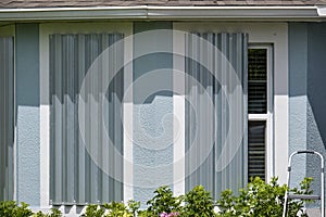 Hurricane shutters made from steel mounted for protection of house windows. Protective measures before natural disaster