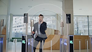 Hurrying man using smartwatch for open office turnstile running on workplace.