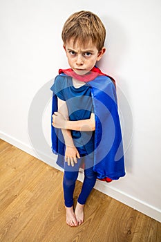 Hurt sad superhero child feeling denigrated, frustrated, scared by parenthood photo