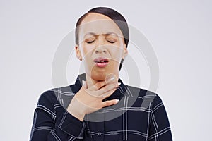 It hurts so bad every time I cough. Studio shot of a young woman suffering with a sore throat against a grey background.