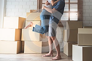 Husband Carrying and hug his wife, who were both happy and celebrating moving into a new house