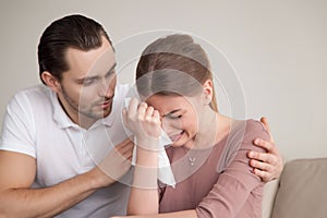 Husband comforting sad crying wife, man consoling sobbing young