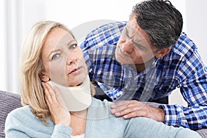 Husband Comforting Wife Suffering With Neck Injury