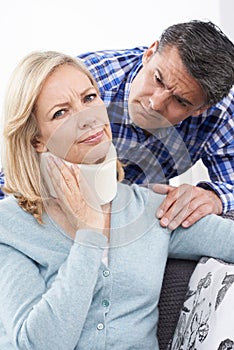 Husband Comforting Wife Suffering With Neck Injury