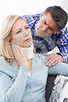 Husband Comforting Wife Suffering With Neck Injury