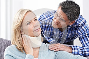 Husband Comforting Wife Suffering With Neck Injury