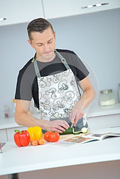 husband cooking dinner from recipe book