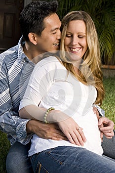 Husband embraceing his pregnant wife`s belly.